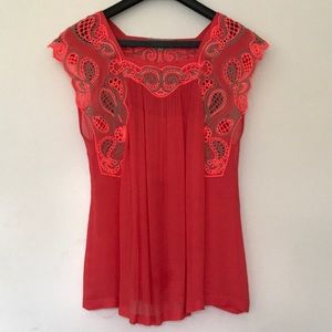 Is a to lace detail coral sleeveless blouse.